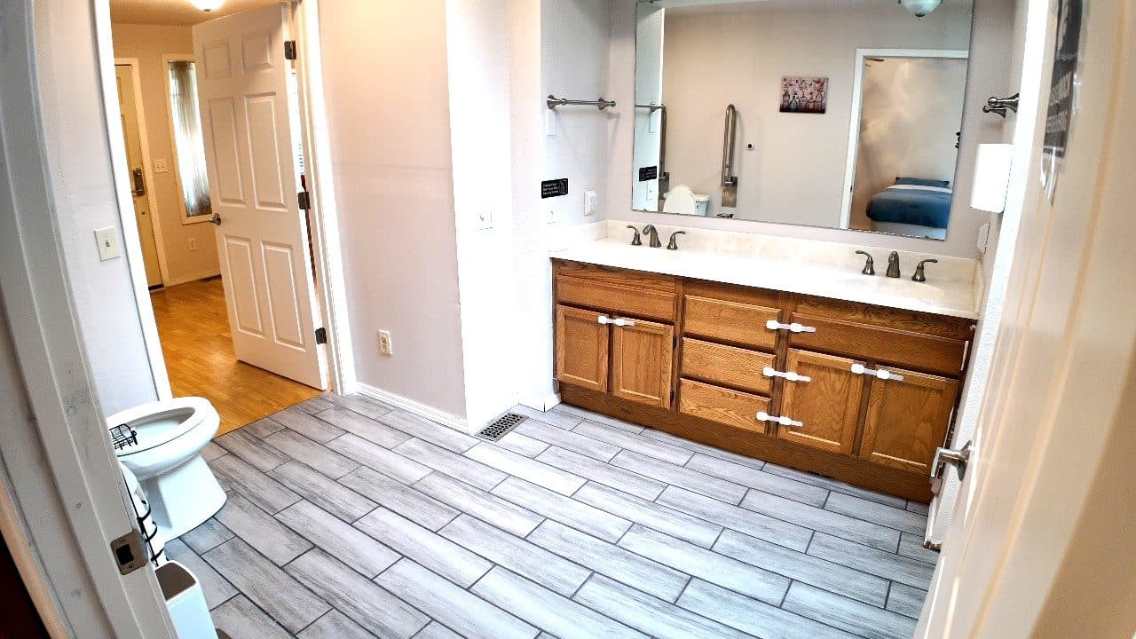 Accessible bathroom with a double vanity, wall grab bars and a wide doorway