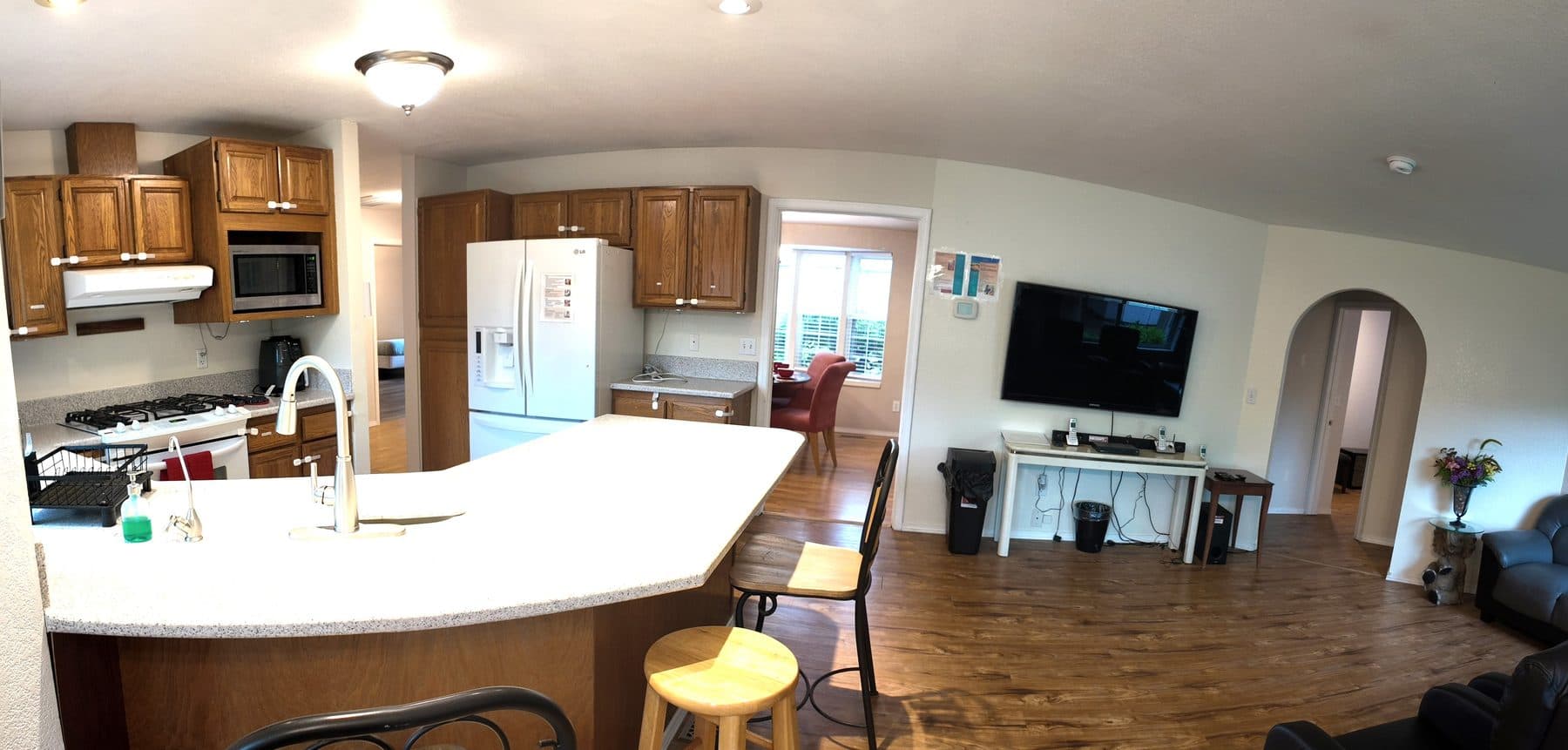 Kitchen with a large prep island and stools, opening into the living area
