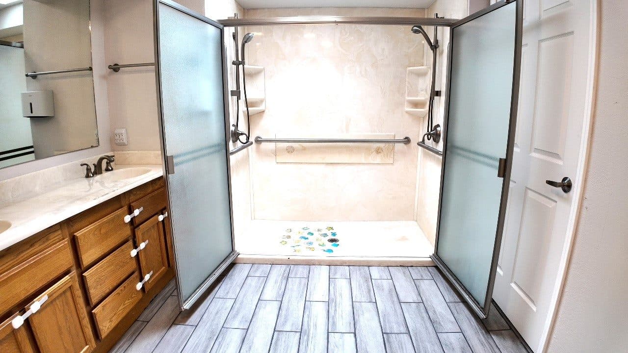 Roll-in shower with a low threshold, grab bars and glass doors that open wide